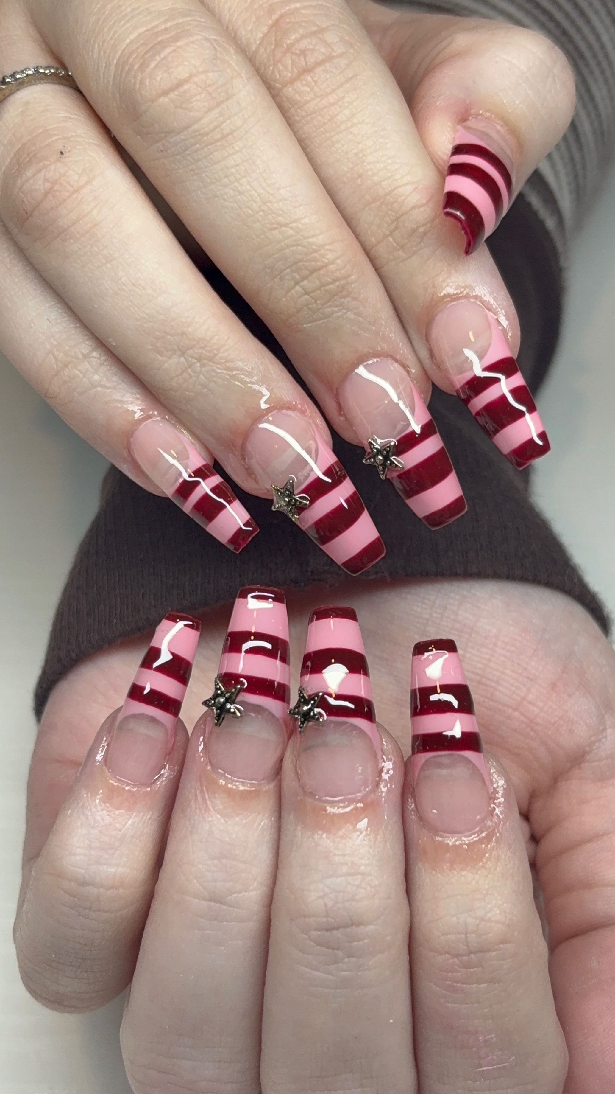Pink and red striped nails with star charms